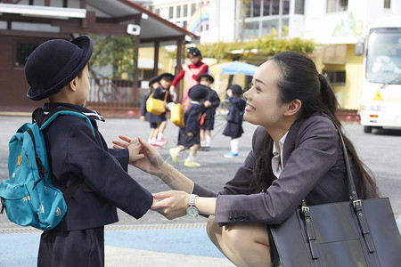 背着书包和妈妈说话的小朋友女商人高清图片素材