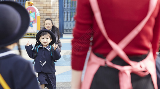 母亲看着孩子跑向老师女生高清图片素材