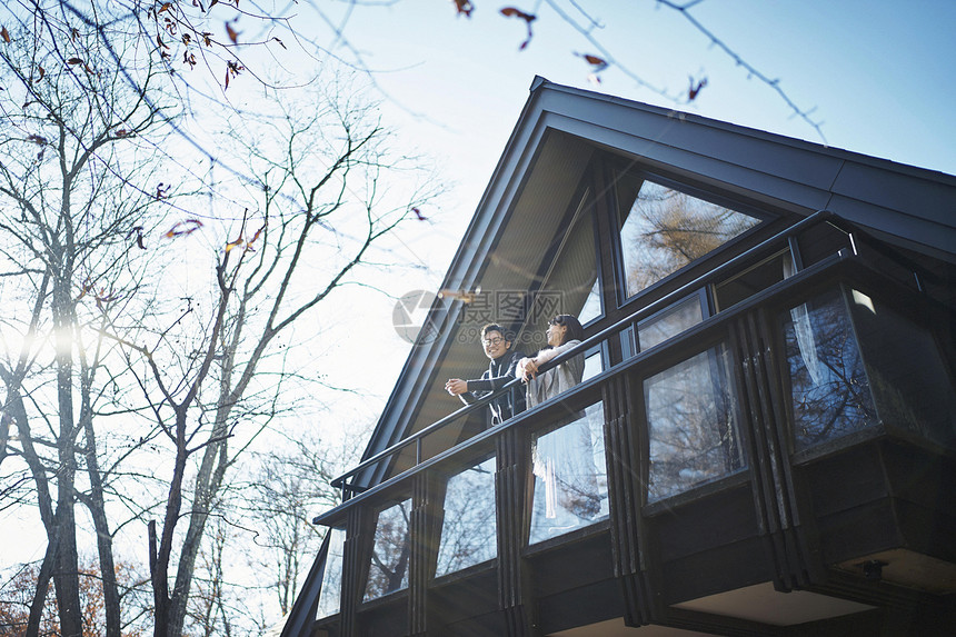在森林度假别墅阳台远望的情侣图片