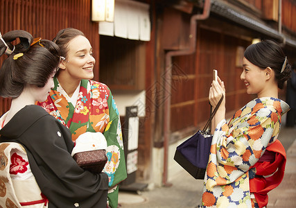 穿着和服与艺伎合影的外国游客高清图片