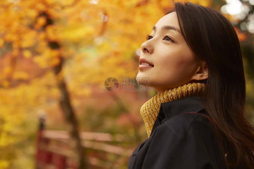 年轻女人观赏秋天枫叶图片