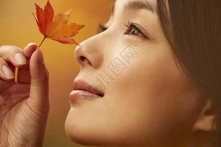 年轻女人观赏秋天枫叶高清图片