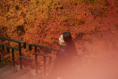 红枫林下的漂亮美女笑容高清图片素材