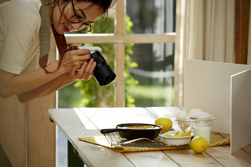 在拍摄美食的时髦美女图片