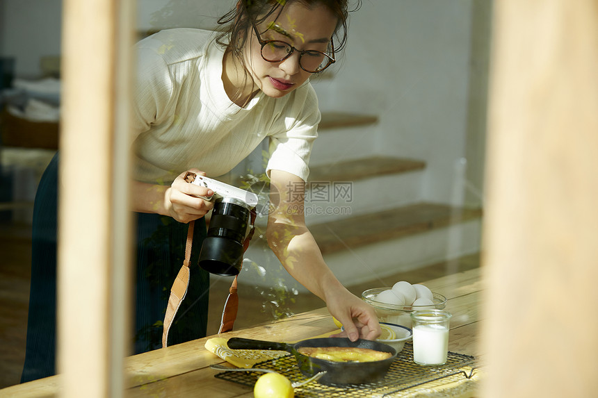 在拍摄美食的时髦美女图片