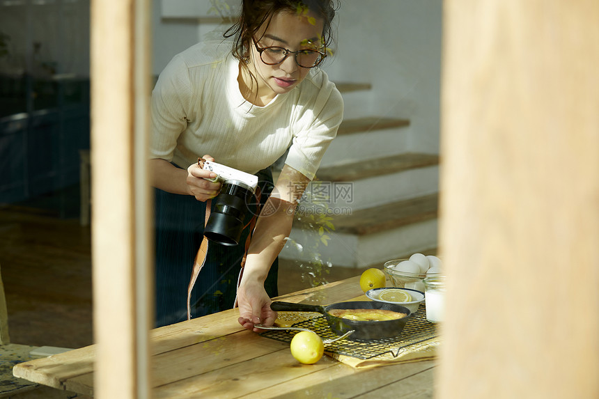 在拍摄美食的时髦美女图片