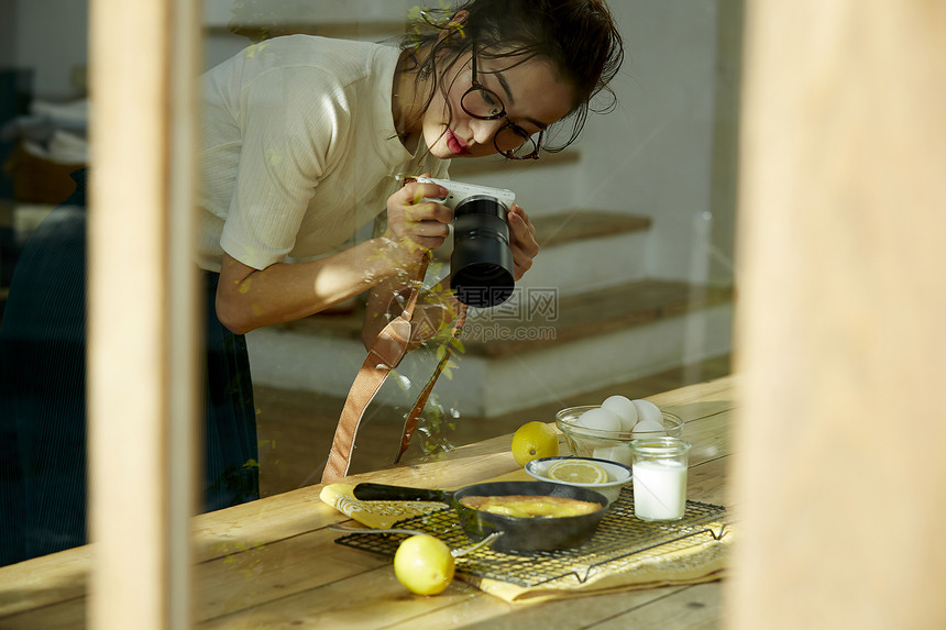 在拍摄美食的时髦美女图片