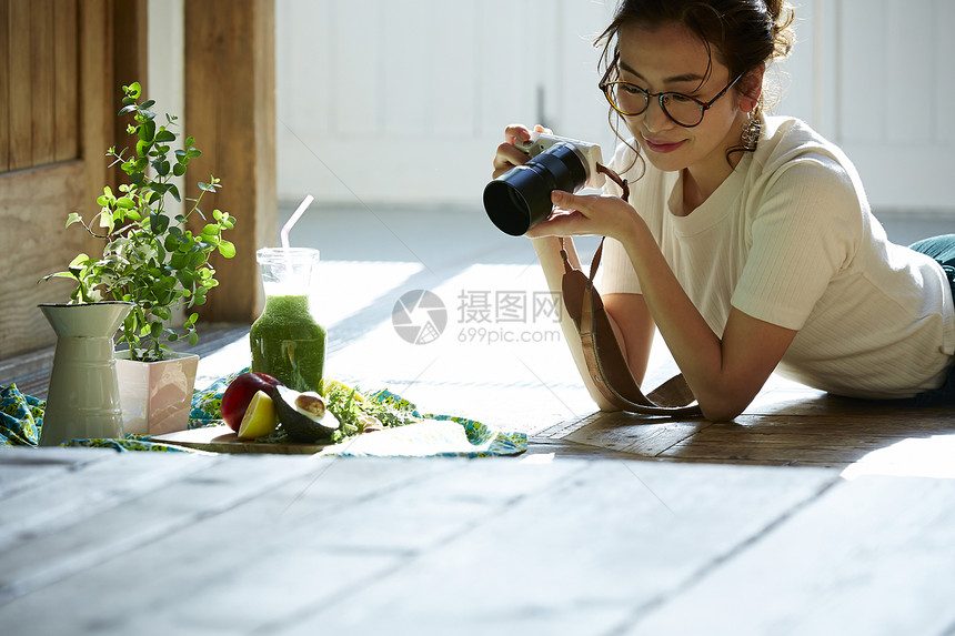 在客厅拍摄美食的时髦美女图片