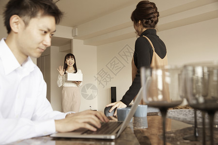 男人坐着用电脑工作女人看着客人图片