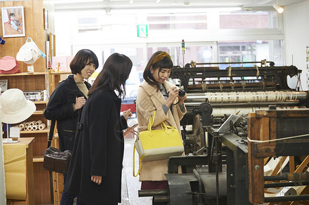 三个女生在印染店里参观背景图片