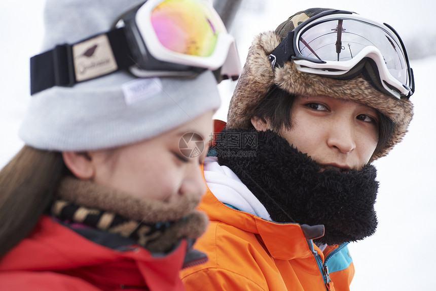 参加俱乐部滑雪活动的情侣在雪地聊天图片