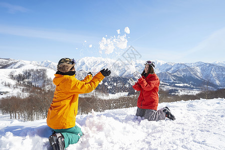 在雪地里玩玩雪的年轻情侣图片