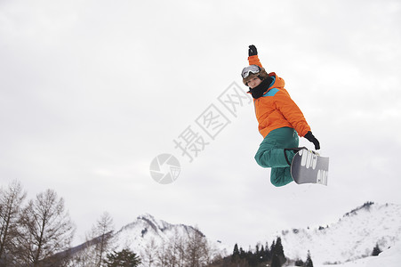 滑雪时跳起的青年男性高清图片