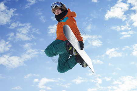 滑雪时跳起展示高难度动作的青年男性图片