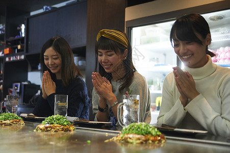 三个女生在做饭前的祈祷料理高清图片素材