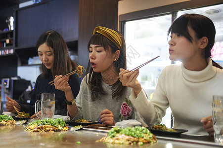 三个女生一起开心的吃大阪烧盘高清图片素材