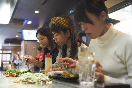 三个女生一起开心的吃大阪烧旅游业高清图片素材