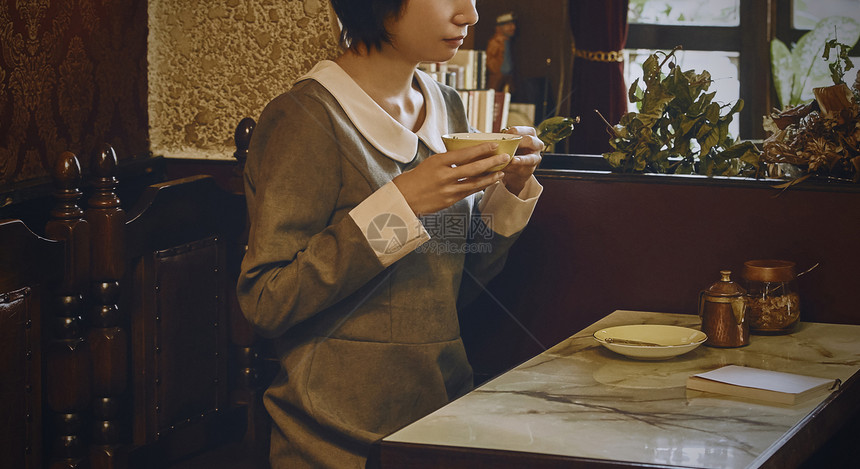 在咖啡馆里看书喝茶的年轻女性图片