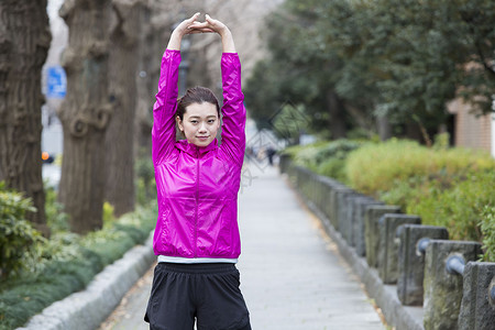 年轻女性在做跑步前的热身运动图片