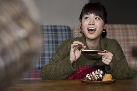 拍摄食物照片的年轻女人图片