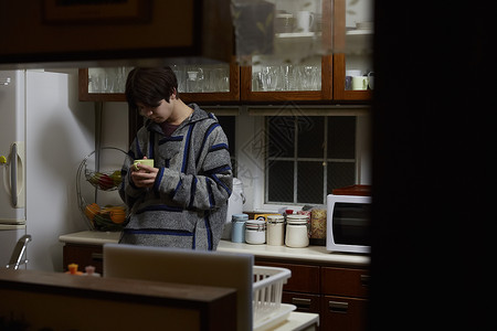 备考的男孩子在厨房内喝饮料高清图片