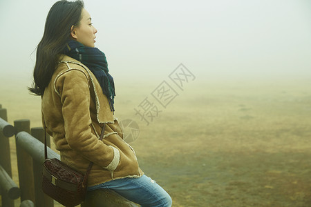 熊本坐在栏杆上向远处看的女孩背景