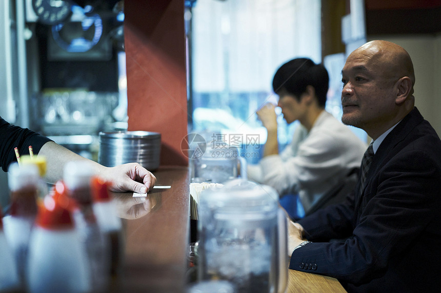 坐着等待食物上桌的男人图片