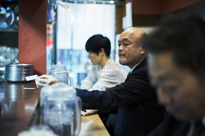 坐着等待食物上桌的男人图片