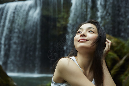 站在小溪边享受瀑布的女人抬头看青年高清图片素材