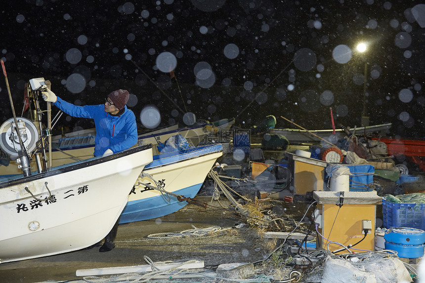 夜晚拉着渔网收获的渔民图片
