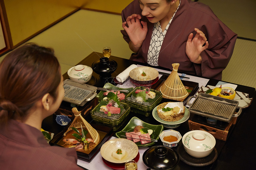 穿着现代和服的两个女人在享受美食图片