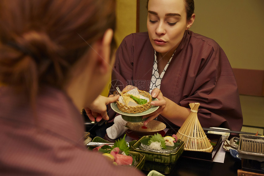 穿着现代和服享受美食的两个女人图片