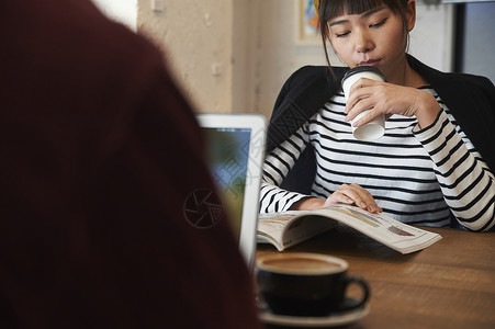 青山书苑喝咖啡看杂志的年轻女性背景
