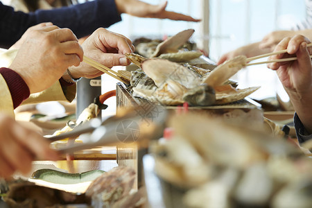 游客吃海鲜烤贝类特写高清图片