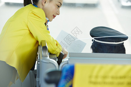 旅游巴士上的女导游在和司机交谈图片