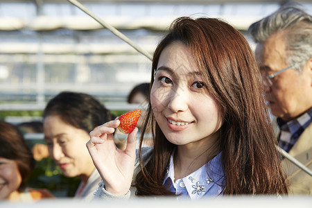 拿着草莓微笑的女孩背景图片