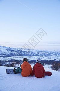 滑雪场上席地而坐的情侣背景图片