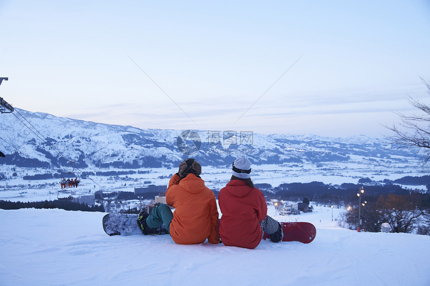  坐在雪地上休息的情侣图片