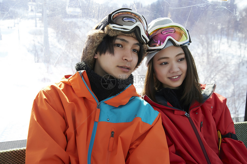 滑雪场上坐缆车的情侣图片