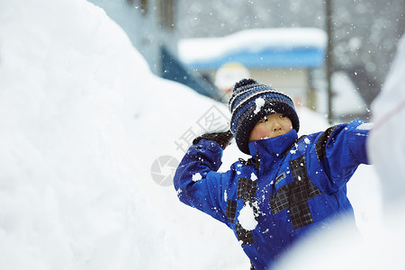 雪地里玩耍打雪仗的小男孩图片