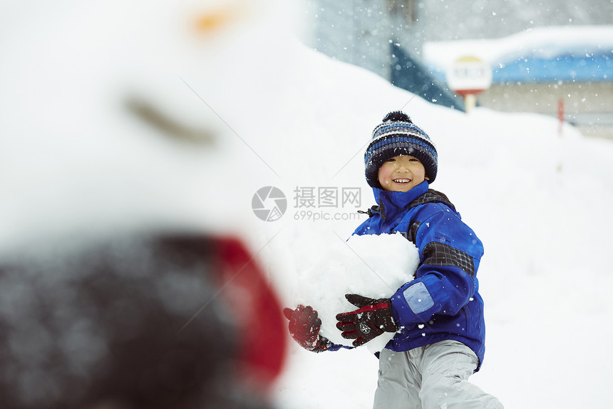 抱着一大块雪的小男孩图片