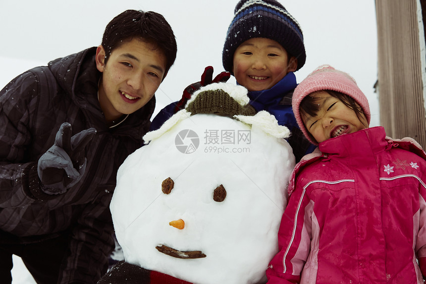 雪地里和雪人开心合照的孩子们图片