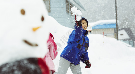 雪地里开心玩耍打雪仗的小男孩图片