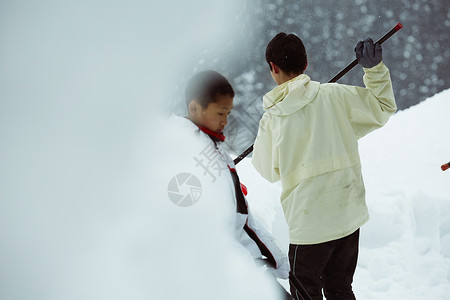 户外用铁锹除雪的男孩图片