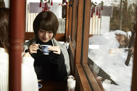 咖啡厅喝着下午茶的年轻女性图片