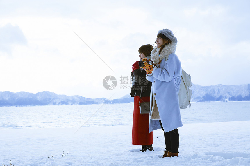 雪景区湖畔站在雪地里的少女们图片