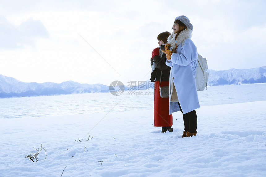 雪景区湖畔站在雪地里的少女们图片