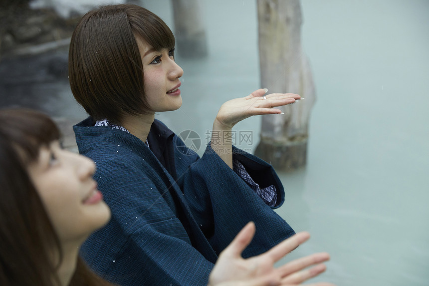 冬季雪天户外泡温泉的少女图片