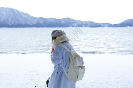 冬天在雪地里漫步背着背包的女孩图片