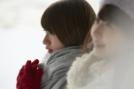 女性游客在雪地里搓手取暖图片